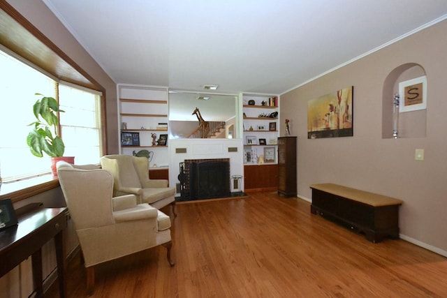 20 Richmond Blvd, Lake Grove, NY 11755 - living room with wood finished floors, built in shelves, crown molding, and a brick fireplace