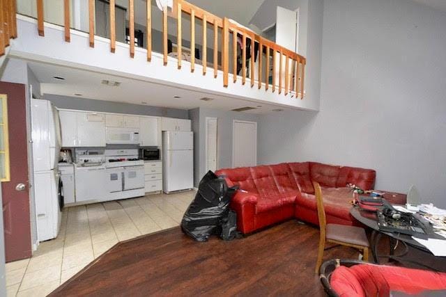 20 Richmond Blvd, Lake Grove, NY 11755 - living room featuring a towering ceiling and light wood-style flooring