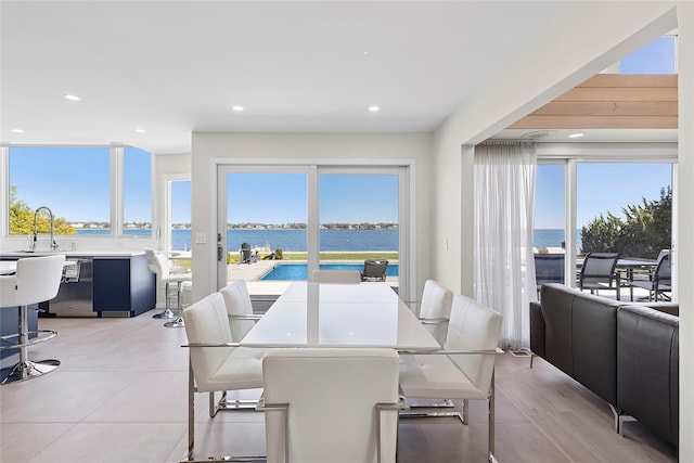 dining area with recessed lighting, a water view, and a wealth of natural light