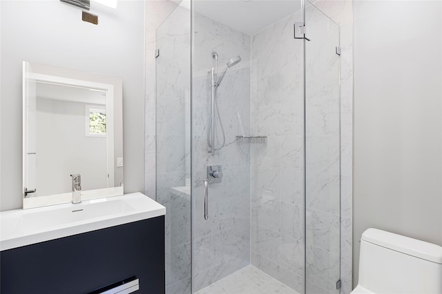 full bath with a marble finish shower, vanity, and toilet