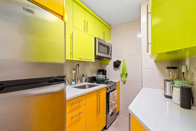 83-25 98th St Unit 3T, Woodhaven, NY 11421 - kitchen featuring stainless steel appliances, a sink, light countertops, tile walls, and yellow cabinetry
