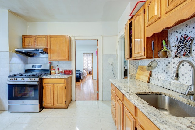 121-41 6th Ave, College Point, NY 11356 - kitchen with gas range, light stone countertops, a sink, and extractor fan