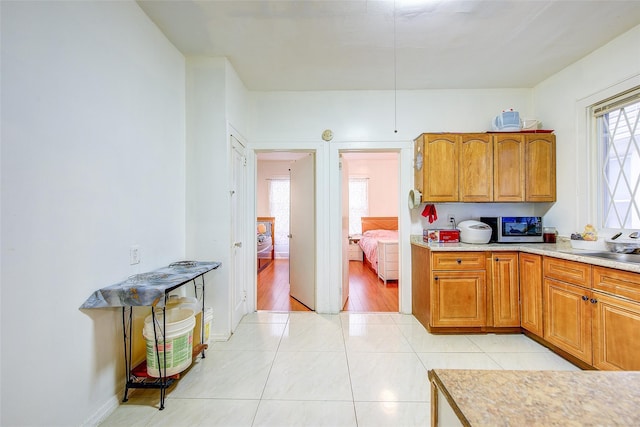 121-41 6th Ave, College Point, NY 11356 - kitchen with a sink, brown cabinetry, light tile patterned flooring, light countertops, and stainless steel microwave