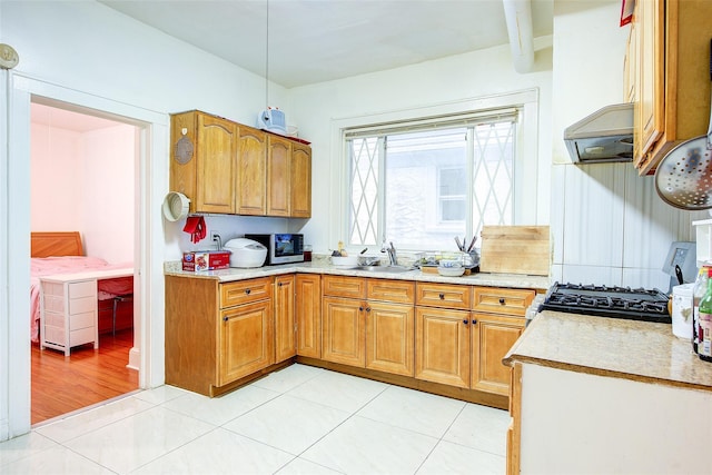 121-41 6th Ave, College Point, NY 11356 - kitchen with a sink, brown cabinets, light countertops, stainless steel microwave, and under cabinet range hood