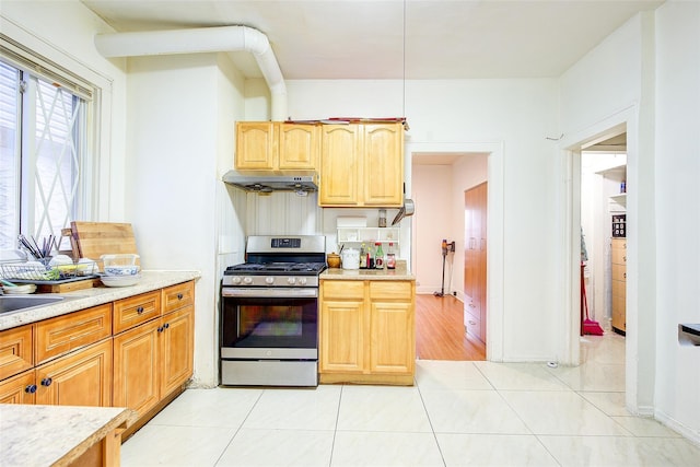 121-41 6th Ave, College Point, NY 11356 - kitchen with stainless steel range with gas cooktop, light tile patterned floors, under cabinet range hood, and light countertops