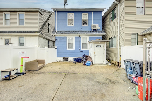 121-41 6th Ave, College Point, NY 11356 - rear view of house featuring a shingled roof, a patio, fence, and a wall mounted air conditioner