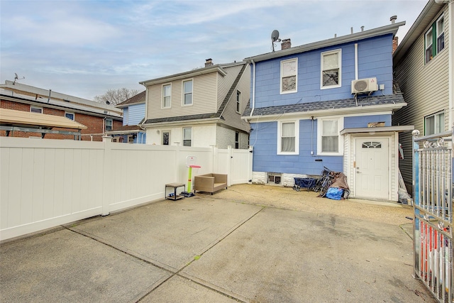 121-41 6th Ave, College Point, NY 11356 - rear view of house with roof with shingles, a chimney, fence, a wall mounted AC, and a patio