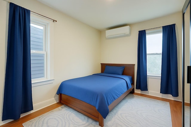 121-41 6th Ave, College Point, NY 11356 - bedroom featuring a wall mounted AC and wood finished floors