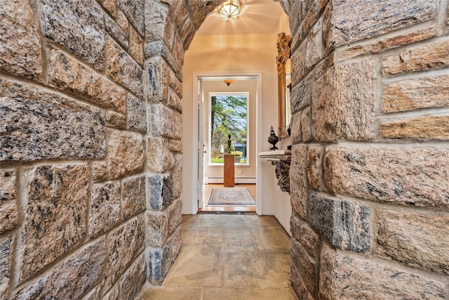 interior space with a baseboard radiator and stone tile flooring