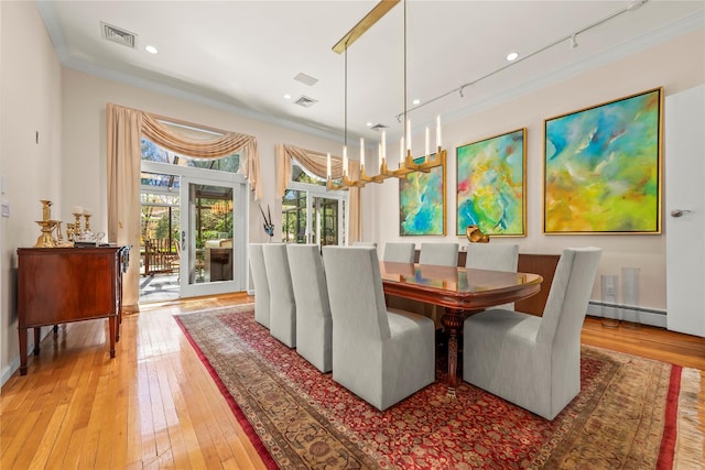 dining area with visible vents, light wood-type flooring, and ornamental molding