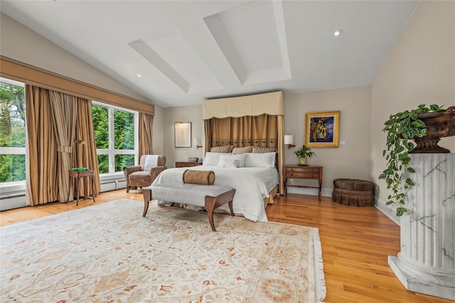 bedroom with light wood-type flooring, multiple windows, and vaulted ceiling