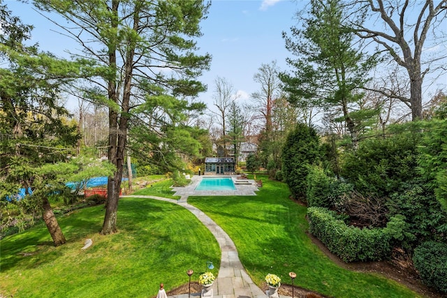 view of home's community with a pool and a yard