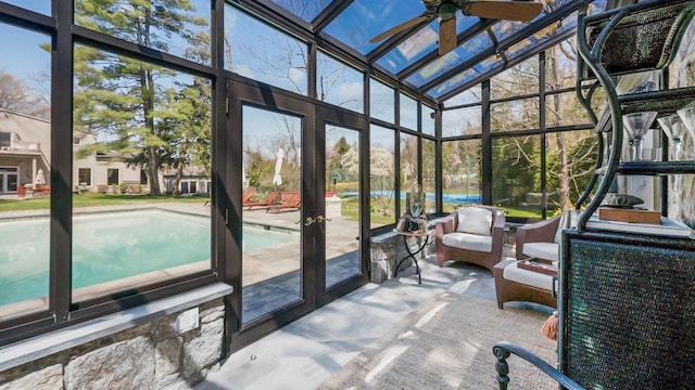 sunroom / solarium with a ceiling fan and french doors