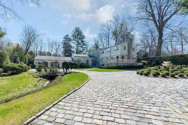 view of property's community with a yard and curved driveway