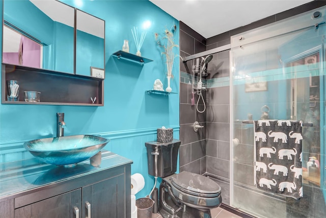 full bath featuring vanity, toilet, a stall shower, and wainscoting