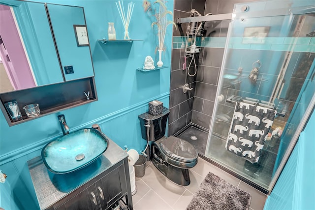 bathroom featuring a shower stall, toilet, vanity, and tile patterned floors