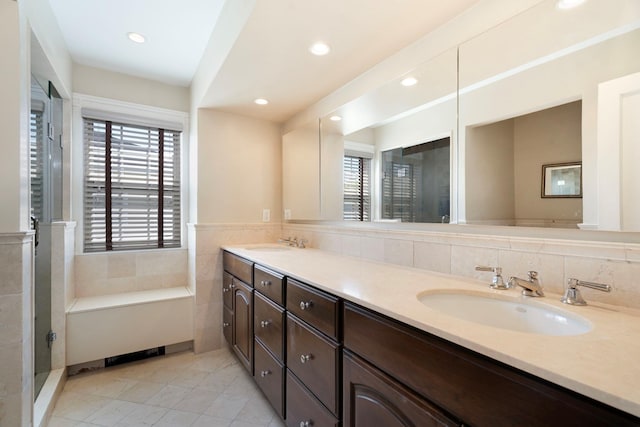 bathroom with double vanity, recessed lighting, a sink, and a stall shower