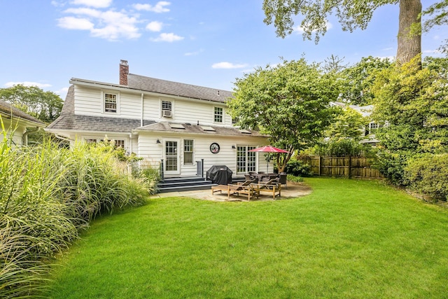 rear view of house with fence, entry steps, a chimney, a patio, and a yard