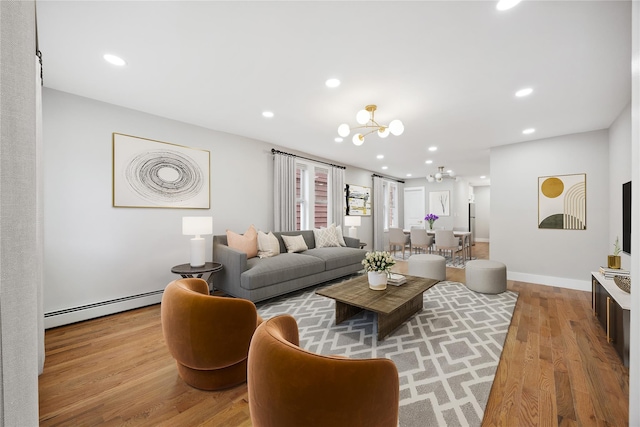 living room with a baseboard radiator, wood finished floors, an inviting chandelier, baseboards, and recessed lighting