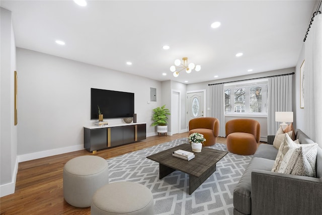 living room featuring a baseboard radiator, wood finished floors, a chandelier, baseboards, and recessed lighting