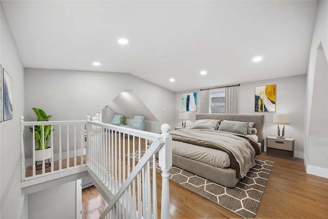 bedroom featuring baseboards, vaulted ceiling, wood finished floors, and recessed lighting