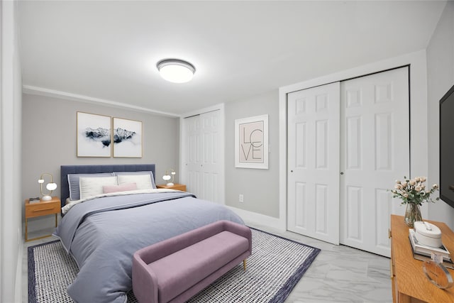 bedroom featuring two closets and marble finish floor
