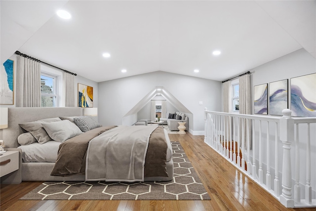 bedroom with multiple windows and hardwood / wood-style flooring