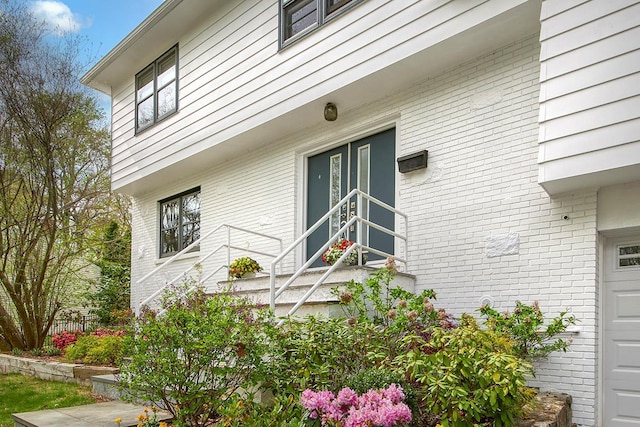 doorway to property featuring brick siding