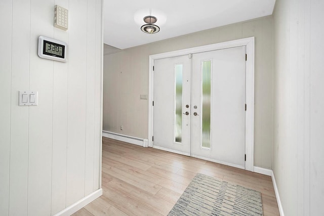 entryway with baseboards, light wood-type flooring, and a baseboard radiator
