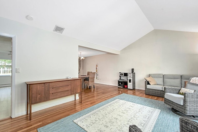 living room featuring visible vents, an inviting chandelier, wood finished floors, baseboards, and vaulted ceiling