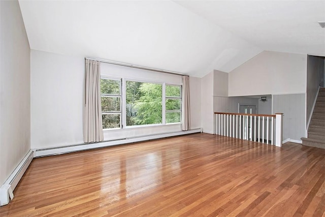 bonus room with vaulted ceiling, a baseboard heating unit, wood finished floors, and stairs