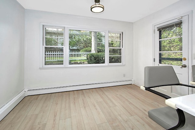 interior space featuring baseboards, wood finished floors, and a baseboard radiator