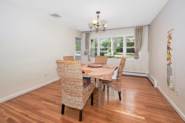 dining area featuring visible vents, baseboard heating, wood finished floors, baseboards, and a chandelier