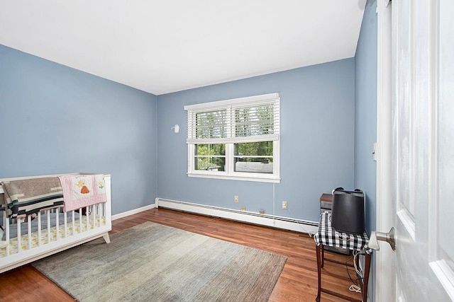 bedroom featuring baseboards, wood finished floors, and baseboard heating