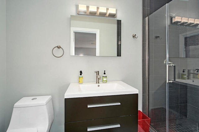 bathroom featuring toilet, a shower stall, and vanity