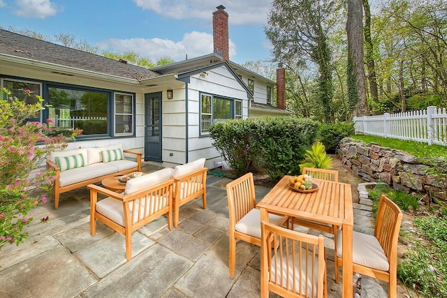 exterior space with fence, outdoor dining area, and an outdoor hangout area