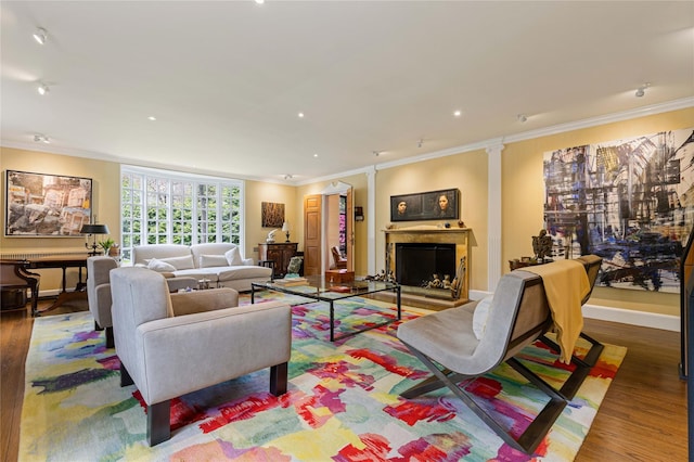 living room with crown molding, wood finished floors, a fireplace, baseboards, and recessed lighting