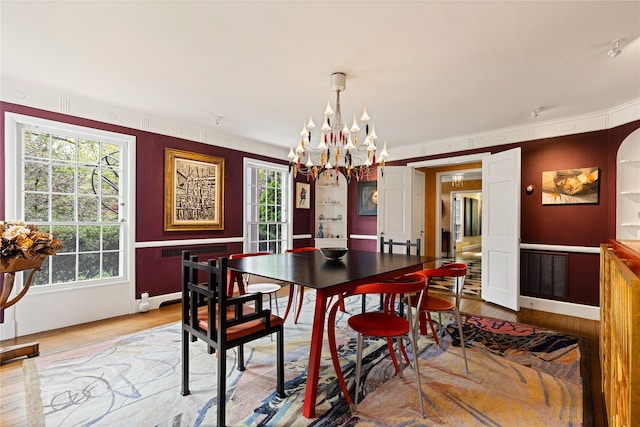 dining room with a chandelier, plenty of natural light, and light wood-type flooring