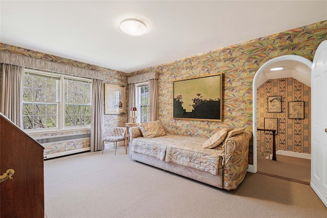 living room with carpet floors, arched walkways, wallpapered walls, and baseboards