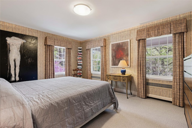 carpeted bedroom featuring radiator heating unit, baseboards, and wallpapered walls