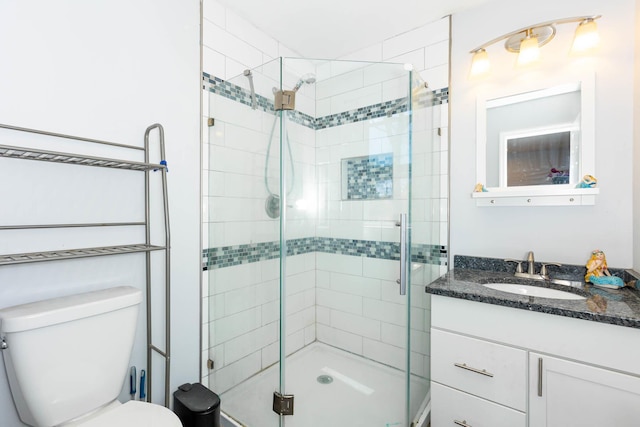 full bathroom featuring vanity, toilet, and a shower stall
