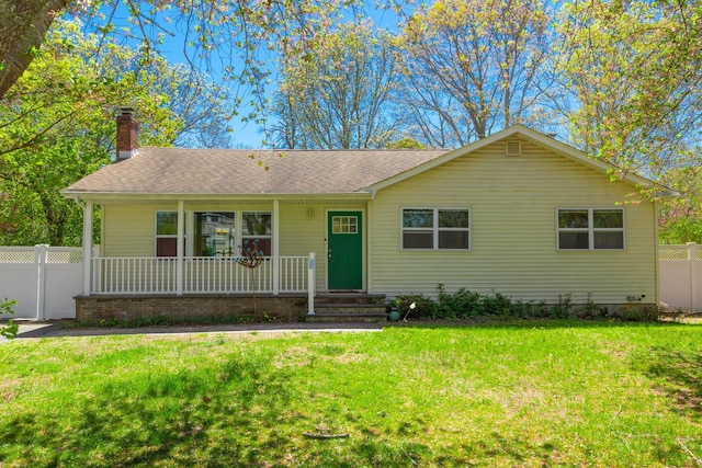 ranch-style home featuring covered porch, fence, a chimney, and a front lawn