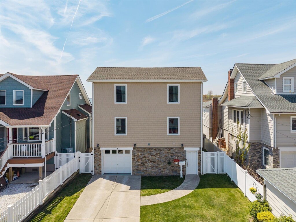 19 W Ave, Lawrence, NY 11559 - view of front facade with a gate, stone siding, a front yard, and a garage