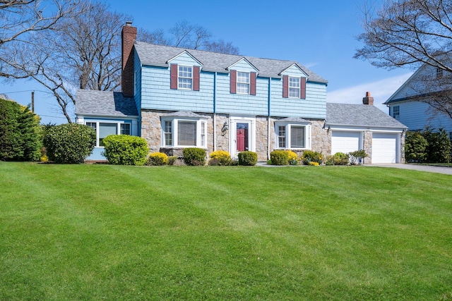 colonial-style house featuring a chimney, a garage, aphalt driveway, and stone siding