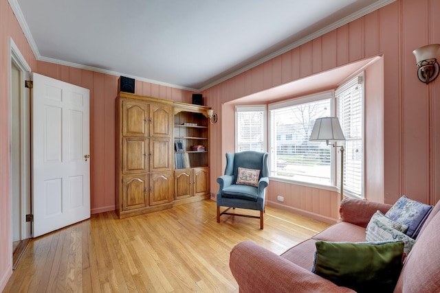 sitting room featuring crown molding, baseboards, and light wood-type flooring