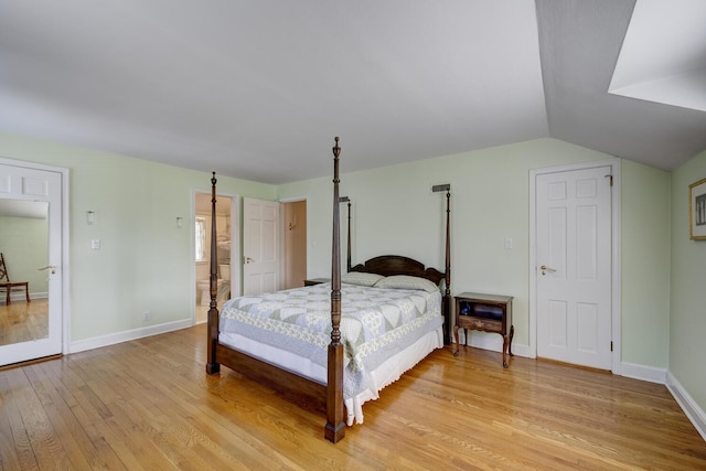 bedroom featuring lofted ceiling, light wood finished floors, and baseboards