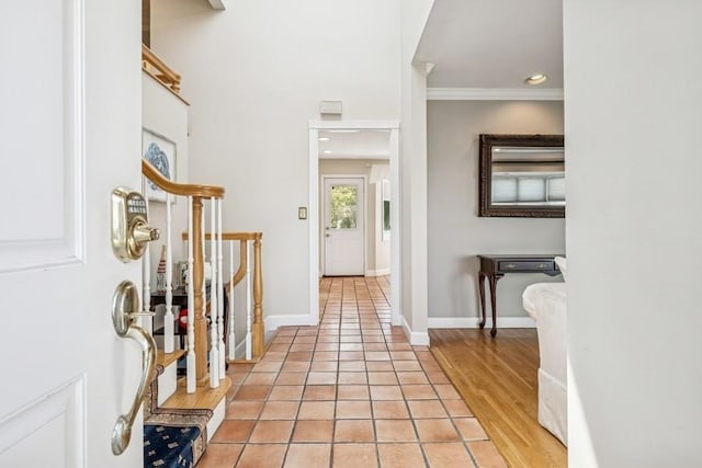 foyer entrance with baseboards, ornamental molding, and light tile patterned floors