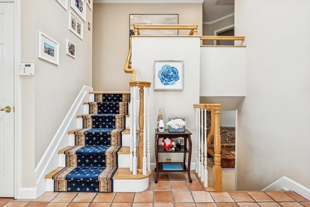 stairway featuring baseboards, ornamental molding, and tile patterned flooring