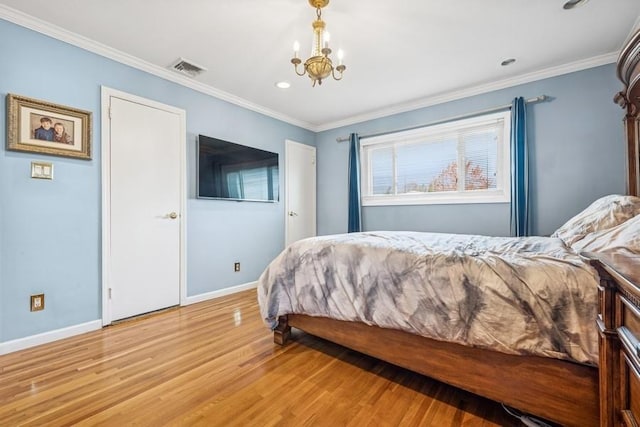 bedroom with crown molding, an inviting chandelier, light wood-style flooring, baseboards, and visible vents