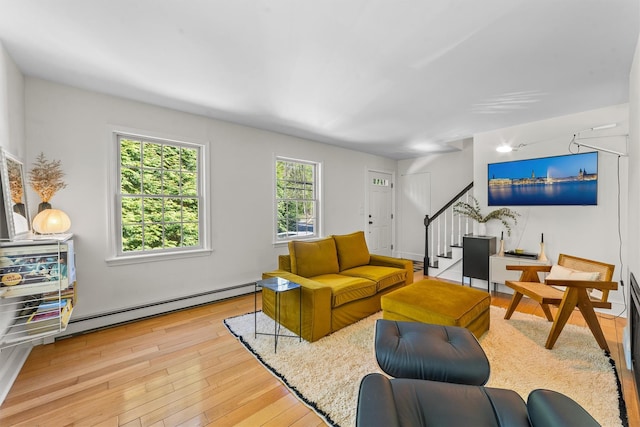 living room featuring hardwood / wood-style flooring, stairway, and a baseboard radiator